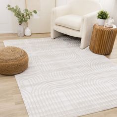 a living room area with a chair and rug on the floor, potted plant next to it