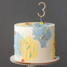 a birthday cake with sprinkles and the number 3 on it's top