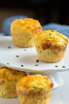 three small muffins on a white plate with green garnish and parsley