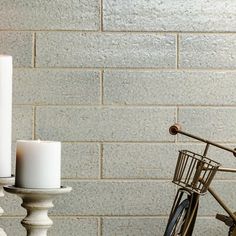 two white candles sitting on top of a table next to a bike and candle holder