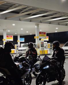 three people on motorcycles at a gas station