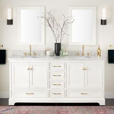 a bathroom with two sinks and mirrors on the wall next to a rug in front of it