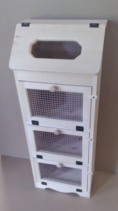 a white wooden cabinet with three drawers