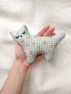 a hand holding a stuffed animal in the shape of a star