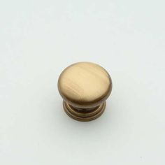 an antique brass cabinet knob on a white background