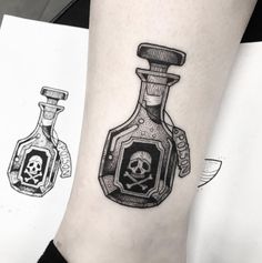 a skull in a bottle tattoo on the ankle