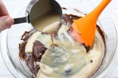 someone is mixing chocolate and cream in a bowl