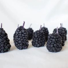 small blackberries are lined up on a white surface