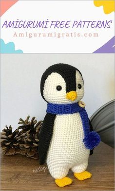 a crocheted penguin with a blue scarf on it's head is standing next to pine cones