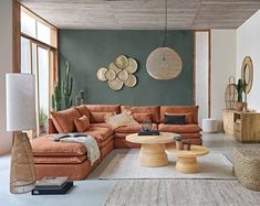 a living room filled with lots of furniture next to a large window covered in plants