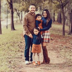 a family poses for a photo in the woods with their toddler son and sister