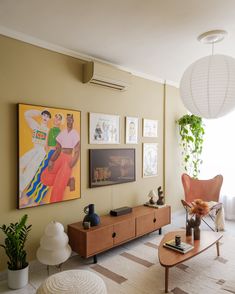 a living room filled with furniture and pictures on the wall above it's coffee table