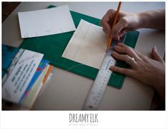 a person is cutting up some paper with a pencil and ruler on top of it