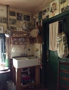 a kitchen with pictures on the wall and a sink in front of a green door