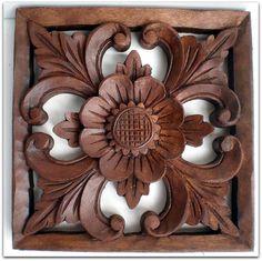 an intricately carved wooden panel with flowers and leaves on the center, is shown