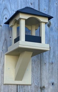 a bird house on the side of a wooden fence