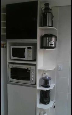 there is a microwave, toaster and coffee maker on the shelf in this kitchen