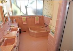 a pink bathroom with two sinks and a bathtub