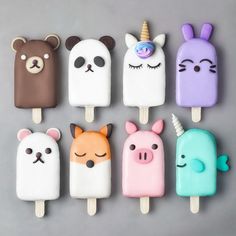 some kind of ice lolly pops with animals and unicorns on them in pastel colors