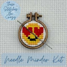 the needle marker kit includes a cross - stitch pattern and an embroidered badge with a smiley face on it