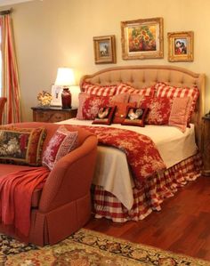 a red and white bed in a bedroom with pictures on the wall