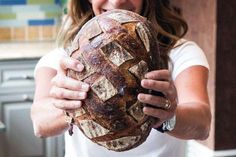 a woman holding a loaf of bread in her hands