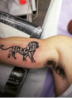 a man laying in bed with a tattoo on his arm