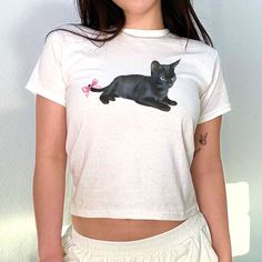 Introducing our Cat With Bow Preppy Baby Tee! Stay stylish with this hot and coquette 90s style top, perfect for any cat lover. Aesthetic and comfortable, this is a must-have addition to your wardrobe. Get yours now! The model is wearing an XS size. Our size guide ensures a perfect fit. Coquette Graphic Tee, Cute Shirt Designs Aesthetic, Cat Lover Aesthetic, Baby Tees Aesthetic, Graphic Tees Aesthetic, Cat With Bow, Preppy Baby, Lover Aesthetic, Wishlist 2024