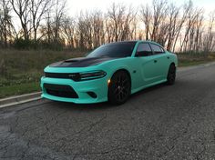 a blue dodge charger parked on the side of the road