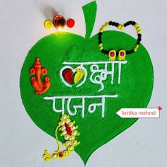 a green heart shaped decoration with words written in the middle and two small beads hanging from it