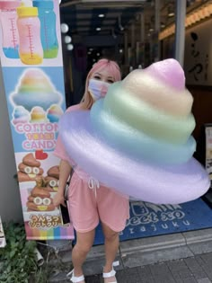 a woman wearing a face mask holding an ice cream cone in front of a store