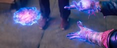 two people with glowing hands on the ground and one person holding something in their hand