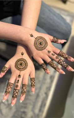 two hands with henna tattoos on them