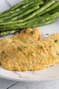 a white plate topped with chicken and asparagus