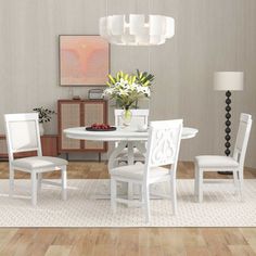 a white table and chairs in a room with wood flooring next to a lamp