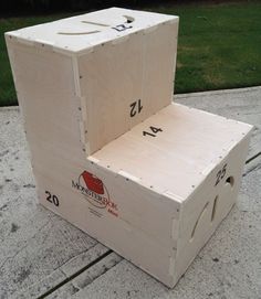 a wooden box sitting on top of a cement floor next to a grass covered field