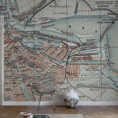 an old map is on the wall next to a vase