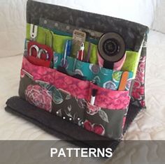 a purse that is sitting on top of a bed with pens and scissors in it