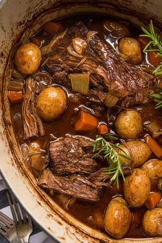 a pot filled with stew and potatoes on top of a stove