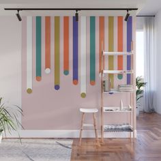 a room with pink, orange and blue stripes on the wall next to a ladder