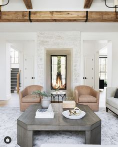 a living room with two couches and a fire place in the fireplace, surrounded by white walls