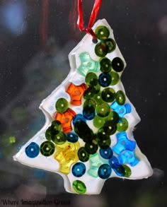 a glass christmas tree ornament hanging from a window