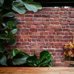 an ornately decorated cake sitting on top of a wooden table next to a brick wall