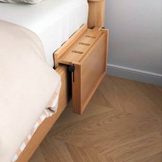 a bed with a wooden headboard and drawers on the bottom shelf next to it