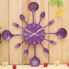 a purple clock with spoons and forks on the face against a wooden wall background