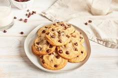 chocolate chip cookies on a plate next to a glass of milk