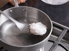 a person stirring something in a saucepan on the stove