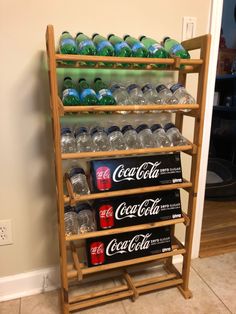 a wooden shelf filled with lots of soda bottles and cans on top of each other