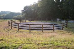 a horse pen in the middle of a grassy field