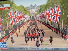 a group of people riding horses down a street with flags in the shape of union jacks